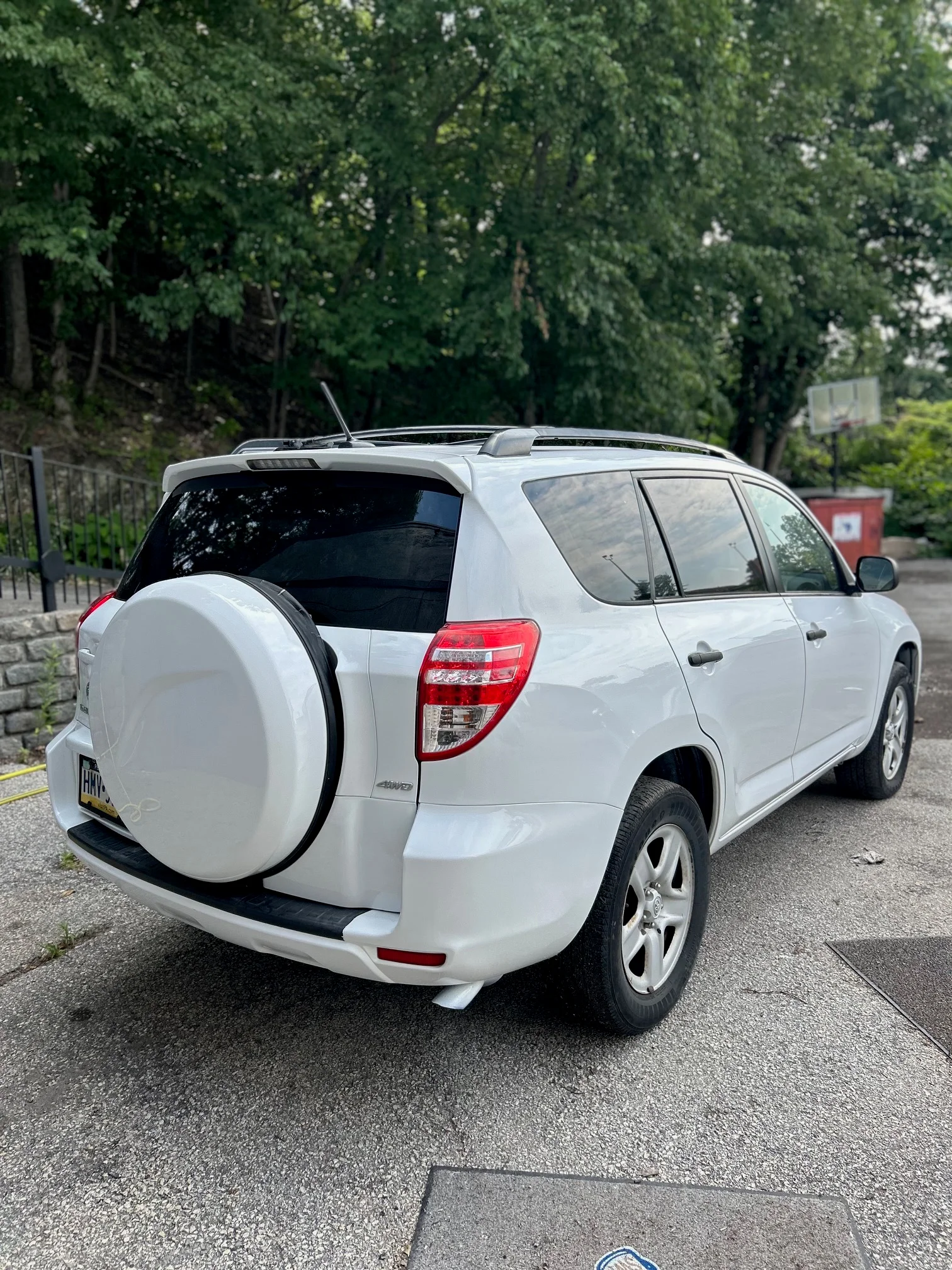 White SUV parked outdoors, showing rear view and spare tire.